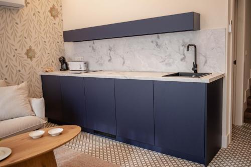 a kitchen with blue cabinets and a sink at Royar Casa del Reloj - Apartamentos Premium frente Catedral in Jaén
