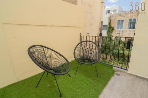 two chairs sitting on a balcony with green grass at A lovely 1BR studio home in Rabat with WIFI & AC by 360 Estates in Rabat