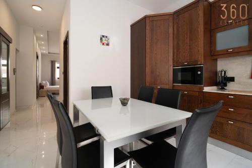 a dining room with a white table and black chairs at A lovely 1BR studio home in Rabat with WIFI & AC by 360 Estates in Rabat