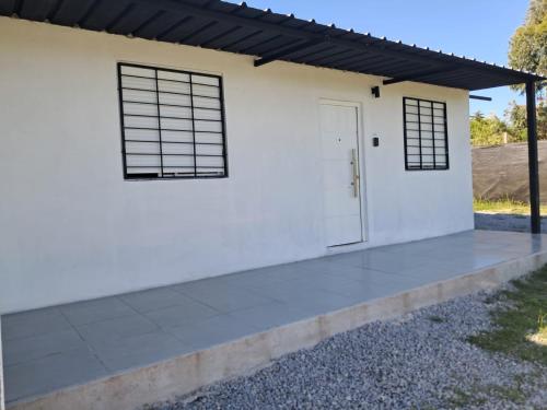 een wit huis met een witte deur en ramen bij Casa bella in Durazno