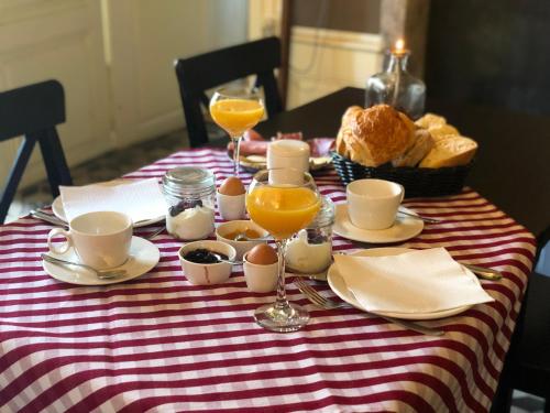 a table with breakfast food and glasses of orange juice at Domaine les Darbonnets - Chambres et Table d'hôtes in Chavannes-sur-Reyssouze