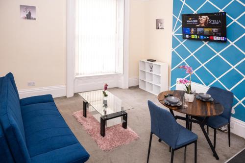 a living room with a blue couch and a table at Rugby 1-BR Apt, Parking, City Centre, Sleeps 3 in Rugby
