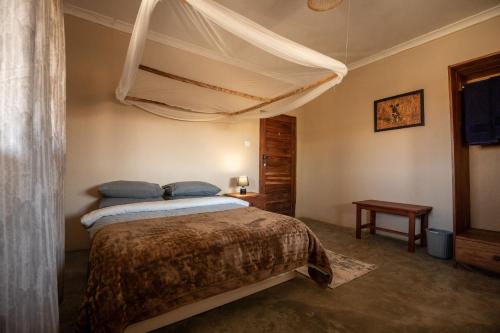 un dormitorio con una cama con dosel en Rain Tree Camp, en Chunga