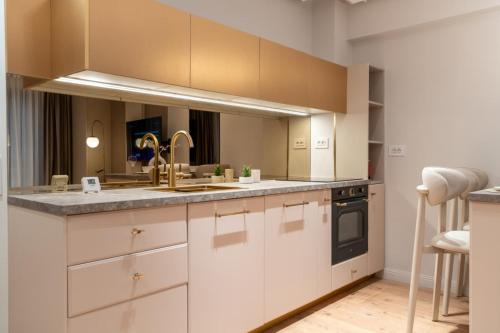 a kitchen with white cabinets and a sink at Elegant Ivory Studio by Blvd 16B7 - Quiet Garden View in Pipera in Pipera