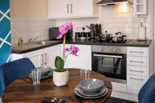 a kitchen with a wooden table with a dining room at Rugby 1-BR Apt, Parking, City Centre, Sleeps 3 in Rugby