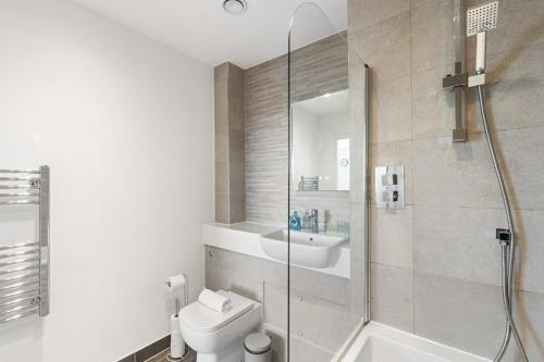 a bathroom with a shower and a toilet and a sink at Sleek & Stylish Apartment in the Best Area in Beckenham