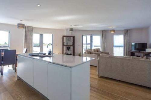 a kitchen and living room with a white counter top at The Luxurious Semi-Circle in Cambridge