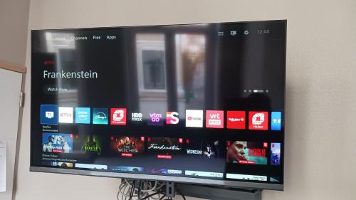 a flat screen tv hanging on a wall at Suite Blanche in Ostend