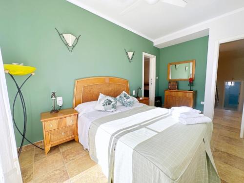 een slaapkamer met een bed en een groene muur bij Villa en la Playa I 5BR I 5 WC I Piscina Privada in Sueca