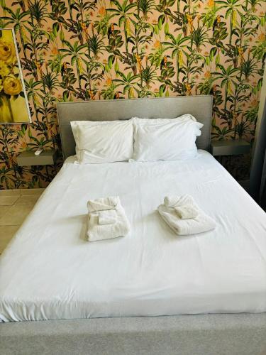 a white bed with two white towels on it at Relaxed Studio Near the Beach in Jan Thiel