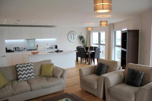 a living room with two couches and a kitchen at The Luxurious Semi-Circle in Cambridge