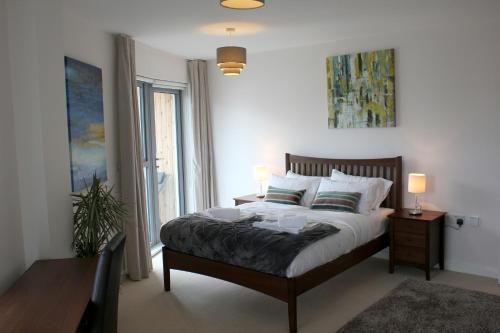 a bedroom with a bed and a table with two lamps at The Luxurious Semi-Circle in Cambridge