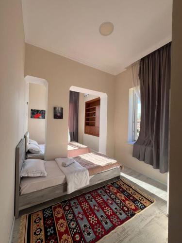 a bedroom with two beds and a rug at Comfortable House the city centr in Kutaisi