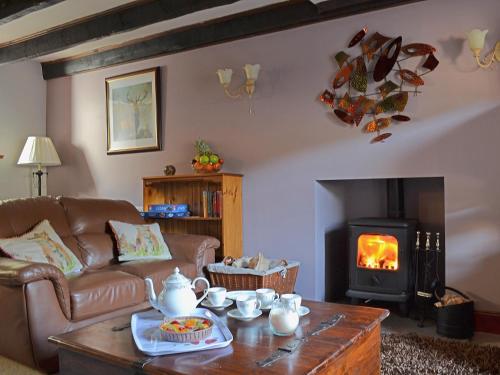 ein Wohnzimmer mit Couch und Kamin in der Unterkunft Craigdarroch Cottage in Strathyre