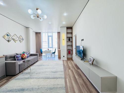 un salon avec un canapé et une télévision dans l'établissement Уютная евродвушка возле Mega Silkway!, à Zhezdi