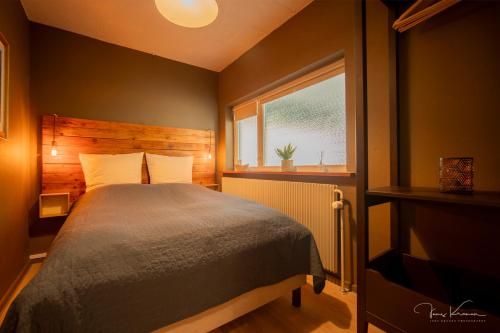 a bedroom with a bed and a window at FeWo Lille Lægehus in Hjørring