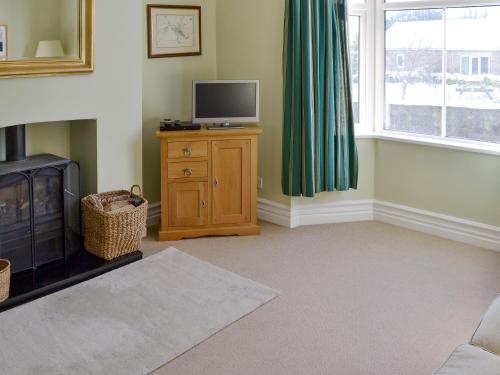 a living room with a tv on a wooden dresser with a tvictericter at Hillcrest in Pickering
