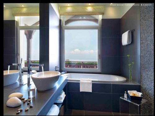 ein Badezimmer mit einer großen Badewanne und einem großen Fenster in der Unterkunft Hôtel Ermitage in Évian-les-Bains