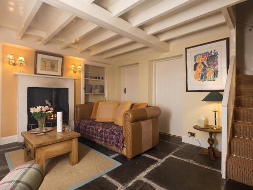 ein Wohnzimmer mit Couch und Kamin in der Unterkunft Big Barns Cottage in Backies