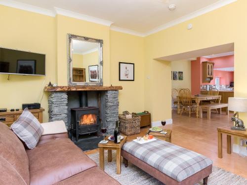 ein Wohnzimmer mit Couch und Kamin in der Unterkunft Grace's Cottage in Port of Menteith