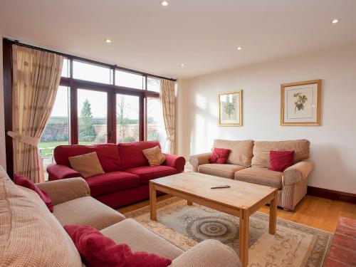 SculthorpeにあるKingfisher Barnのソファ2つとテーブルのあるリビングルーム