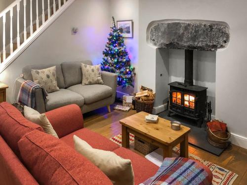 ein Wohnzimmer mit einem Weihnachtsbaum und einer Couch in der Unterkunft Bluebell Cottage in Coniston
