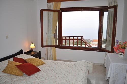 a bedroom with a bed and a large window at Villa Agalianos in Kerames