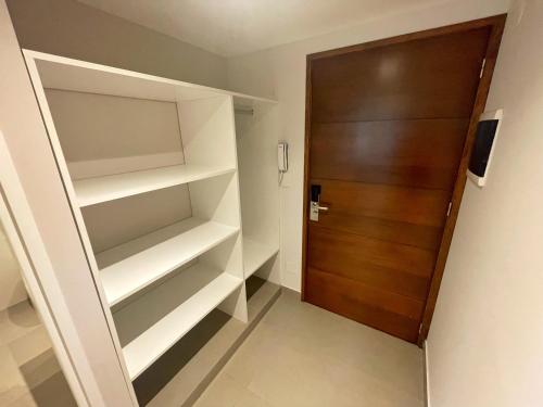 a walk in closet with a wooden door at Otero Coliving - Studio Entero U4 in San Salvador de Jujuy