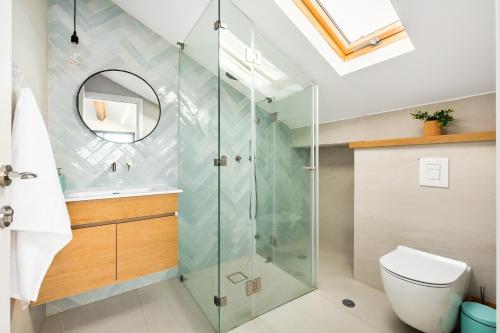 a bathroom with a glass shower and a toilet at Sunny Hilltop Hideaway by Sea N' Rent in Tefahot