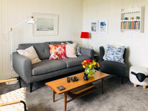 ein Wohnzimmer mit einer Couch und einem Couchtisch in der Unterkunft Owl Cottage in Kilmote