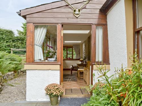 einen Eingang zu einem Haus mit einer hölzernen Pergola in der Unterkunft Old Stones in Glendevon