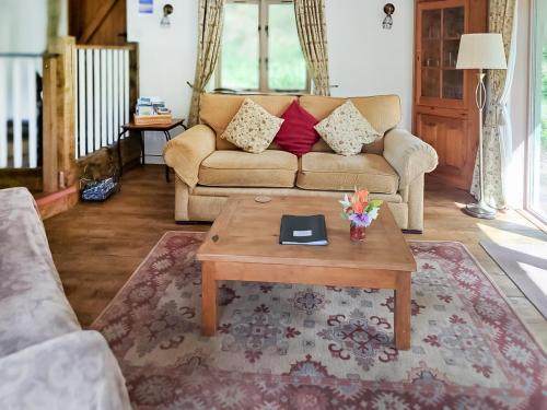 een woonkamer met een bank en een salontafel bij Brook Lodge in Bridford