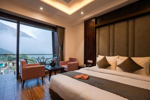 a bedroom with a large bed and a large window at Alt Life Luxe - Uppper Bhagsu Mcleodganj in McLeod Ganj
