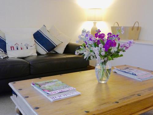 a vase of flowers on a coffee table in a living room at Bramble in Hartland