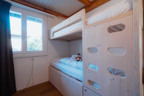 una litera en una habitación con ventana en Apartment Perlita, en Amden