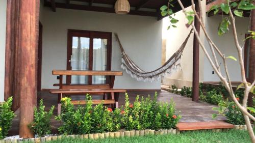 a porch with a hammock on a house at Pousada Encantos do Coqueiro in Luis Correia