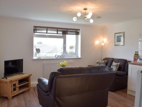 EarbyにあるCan-Y-Mor - Uk13379のリビングルーム(革張りのソファ2台、テレビ付)