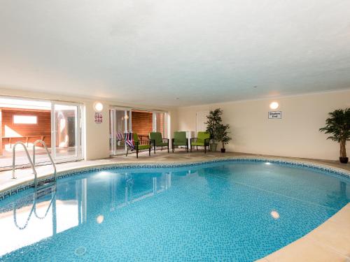 a large swimming pool with chairs and a table at North Dean in Winster
