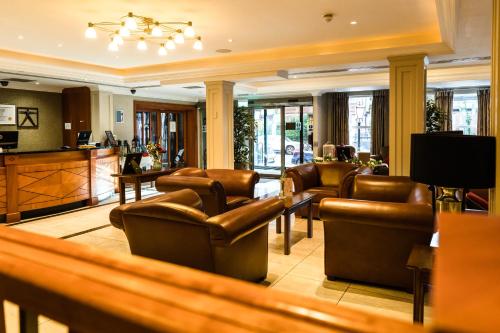een wachtkamer met lederen stoelen en een bar bij The Malone Hotel in Belfast