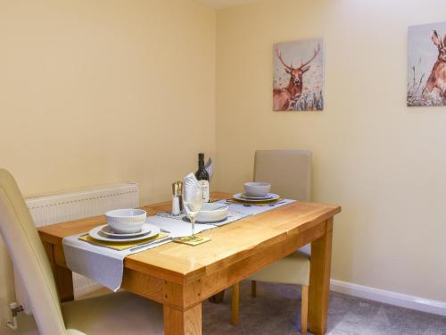 a dining room with a wooden table with chairs at Stone Hill Oast Annexe in Egerton