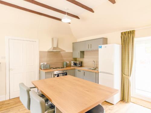 eine Küche mit einem Holztisch und einem weißen Kühlschrank in der Unterkunft Keepers Cottage - Uk30246 in Cray