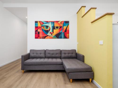 a couch in a room with a painting of a cat at Nenne' Home in Sorrento