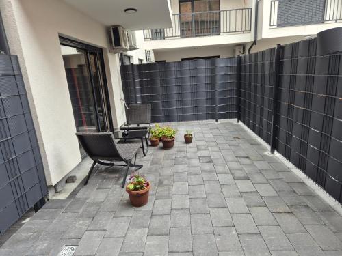 a patio with two chairs and potted plants on it at Meli Deluxe in Prizren