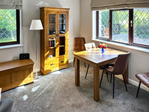 a dining room with a wooden table and chairs at Havre De Calme in Halstead