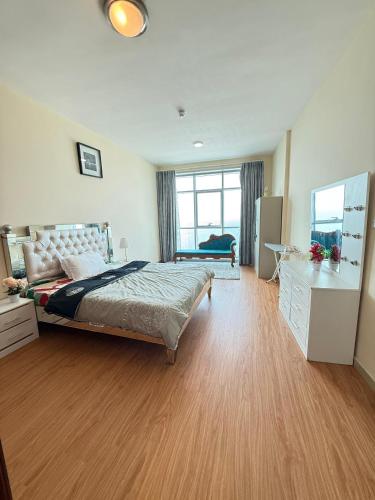 a large bedroom with a bed and a dresser at Full seaview luxury with gym,pool,jacuzzi,sauna,24x7 cafe,beach,restaurants,medical and more in Ajman
