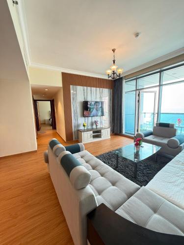 a living room with a couch and a table at Full seaview luxury with gym,pool,jacuzzi,sauna,24x7 cafe,beach,restaurants,medical and more in Ajman 