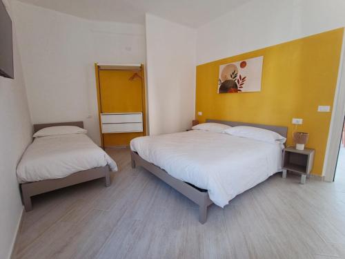 a bedroom with two beds and a yellow wall at Casa Nanni in Genova