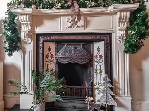 a fireplace with a christmasreath on top of it at Captain's House in Morfa Nefyn