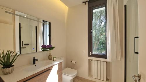 a bathroom with a sink and a toilet and a window at Villa Vacacional Las Encinas in Cuerres