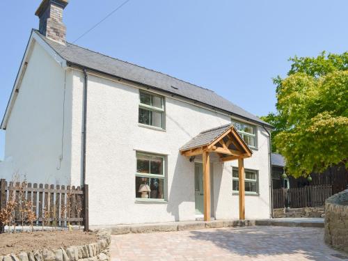 a white house with a wooden an awning at Bryn Salem in Mallwyd
